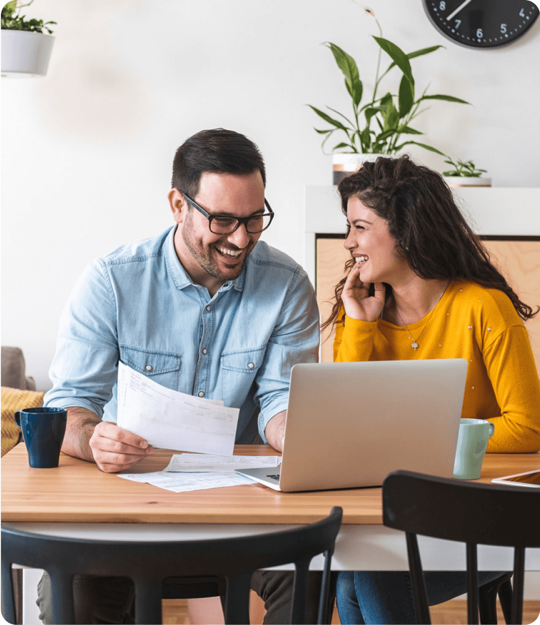 un couple joyeux assis à une table analysant leur rachat de crédits